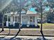 White house with gray shutters, front porch, and mature trees at 248 E Magnolia St, Groveland, FL 34736