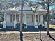 Quaint white house with gray shutters and a tree-lined street at 248 E Magnolia St, Groveland, FL 34736