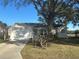 House exterior showcasing a front yard with large oak tree and a view of a lake at 24825 Pine Hl, Leesburg, FL 34748