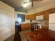 Eat-in kitchen with wood cabinets, white appliances, and laminate flooring at 24825 Pine Hl, Leesburg, FL 34748