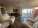 Relaxing living room with light colored sofas, a large TV, and sliding doors to patio at 24825 Pine Hl, Leesburg, FL 34748