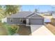 Charming single-story home with a well-manicured lawn, gray exterior and attached garage at 2555 Sw 154Th Place Rd, Ocala, FL 34473