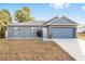 Gray house with blue garage door and landscaping at 2555 Sw 154Th Place Rd, Ocala, FL 34473