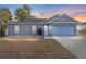 Gray house with a two-car garage at dusk at 2555 Sw 154Th Place Rd, Ocala, FL 34473
