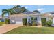 Charming one-story house with a white exterior, attached garage, and neat landscaping at 26607 Racquet Cir, Leesburg, FL 34748