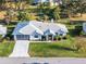 Single-story house with gray roof, attached garage, and green lawn at 27039 Racquet Cir, Leesburg, FL 34748