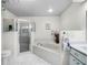 Clean bathroom featuring a walk-in shower and a jetted tub at 27039 Racquet Cir, Leesburg, FL 34748