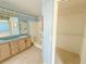 Bathroom featuring double sink vanity, tile floors, separated shower, and closet access at 2707 Privada Dr, The Villages, FL 32162