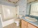 Bathroom with a shower-tub combo, toilet, vanity with a mirror, and floral wallpaper at 2707 Privada Dr, The Villages, FL 32162