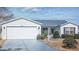 Charming single-story home featuring a two-car garage, landscaped yard, and a well-maintained lawn at 2707 Privada Dr, The Villages, FL 32162