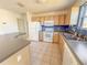 Traditional kitchen featuring light wood cabinets, white appliances, and a tiled floor at 2707 Privada Dr, The Villages, FL 32162