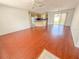 Open-concept living room with hardwood floors, opening to the kitchen and sliding door to the outside at 2707 Privada Dr, The Villages, FL 32162