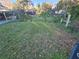 Large grassy side yard with mature trees and some debris at 29 Lonesome Pine Trl, Yalaha, FL 34797