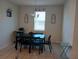 Dining area featuring black dining table, chandelier, window for natural light and tile flooring at 37030 Lake Overlook Dr, Grand Island, FL 32735