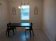 Dining area featuring tile flooring, a dark wood table, and a decorative chandelier, enhanced by natural light from a window at 37030 Lake Overlook Dr, Grand Island, FL 32735