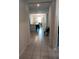 Hallway with gray tile floors leading to an open-concept kitchen and dining area, featuring modern decor and natural light at 37030 Lake Overlook Dr, Grand Island, FL 32735