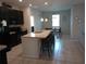 Modern kitchen with an island, barstool seating, granite countertops, stainless steel appliances, and tile flooring at 37030 Lake Overlook Dr, Grand Island, FL 32735