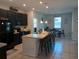 Kitchen with black cabinetry, granite countertops, island with bar seating, and stainless steel appliances at 37030 Lake Overlook Dr, Grand Island, FL 32735