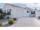 White house with two-car garage and landscaped front yard at 446 Flossmoor Ct, The Villages, FL 32162