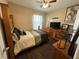Cozy bedroom features wood-look floors, ceiling fan, and bright window with white curtains at 5756 Lakeside Landings Blvd, Winter Haven, FL 33881
