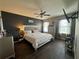 Comfortable main bedroom with dark accent wall, wood-look floors, fan, and large windows at 5756 Lakeside Landings Blvd, Winter Haven, FL 33881
