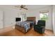 Bright bedroom with wood flooring, a comfy chair, and a ceiling fan at 610 Fannich Ct, Leesburg, FL 34788