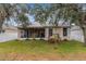 Landscaped backyard with a screened porch and swing at 6342 Sanders Grove Cir, Okahumpka, FL 34762