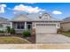 Charming single-story home featuring a metal roof, two-car garage, and welcoming screened porch at 6342 Sanders Grove Cir, Okahumpka, FL 34762