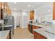 Modern kitchen with wood cabinets, stainless steel appliances, and breakfast bar at 6342 Sanders Grove Cir, Okahumpka, FL 34762