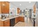Open kitchen with wood cabinets and stainless steel appliances at 6342 Sanders Grove Cir, Okahumpka, FL 34762