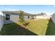Spacious backyard with grassy lawn, privacy fence, and screened patio at 6764 Mary Loop, The Villages, FL 34762