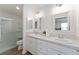 Bathroom with double vanity, large mirrors and a walk-in shower at 6764 Mary Loop, The Villages, FL 34762