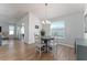 Bright dining room features a round table with four chairs and hardwood flooring at 6764 Mary Loop, The Villages, FL 34762