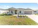 Gray house with a white porch and landscaping at 6764 Mary Loop, The Villages, FL 34762