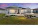 Gray house with a white porch and landscaping at 6764 Mary Loop, The Villages, FL 34762