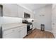 White kitchen with stainless steel appliances and wood flooring at 6764 Mary Loop, The Villages, FL 34762