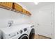 Laundry room with washer, dryer, shelving, and extra storage at 6764 Mary Loop, The Villages, FL 34762