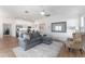 Open concept living room with gray sectional and kitchen view at 6764 Mary Loop, The Villages, FL 34762