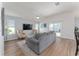 Living room featuring a gray sectional sofa and sliding glass doors at 6764 Mary Loop, The Villages, FL 34762
