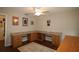 Home office with L-shaped desk, built-in cabinets, and wood flooring at 9059 Se 177Th Grassmere St, The Villages, FL 32162