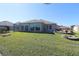 House back exterior view, showcasing a large covered patio at 9059 Se 177Th Grassmere St, The Villages, FL 32162