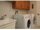 Laundry room with washer, dryer, cabinets, and utility sink at 9059 Se 177Th Grassmere St, The Villages, FL 32162