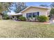 House exterior showcasing landscaping and metal roof at 10406 Lakeshore Dr, Clermont, FL 34711