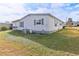 Rear view of the home with landscaping and AC unit at 11 Orangewood Dr, Fruitland Park, FL 34731