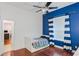 Bedroom with blue walls, hardwood floors, and striped curtains at 1286 Prince Ct, Lake Mary, FL 32746