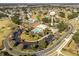 Aerial view of community features including clubhouse, pool, and parking at 1404 Torrey Pines Dr, The Villages, FL 32159
