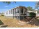 Gray house exterior with landscaping and a small deck at 1404 Torrey Pines Dr, The Villages, FL 32159