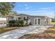 Well-maintained manufactured home with gray siding, landscaped yard, and a decorative driveway at 1404 Torrey Pines Dr, The Villages, FL 32159