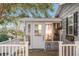 Inviting front entrance with a white door, a wooden deck, and white railings at 1404 Torrey Pines Dr, The Villages, FL 32159
