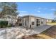 Back of house with gray siding, patio, and landscaping at 1404 Torrey Pines Dr, The Villages, FL 32159